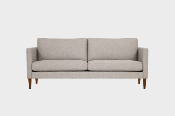 Tuohi-kolmen istuttava sohva beigellä kankaalla verhoiltuna ja jalkana pähkinä puujalka, tuotekuva edestäpäin kuvattuna.
