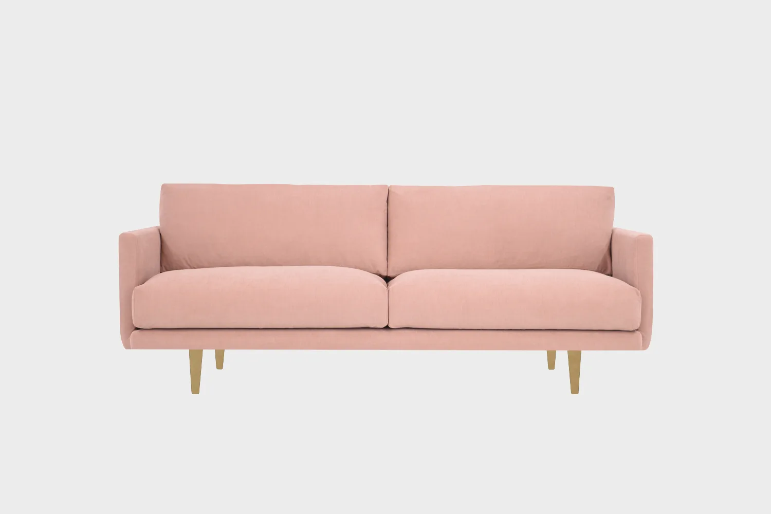 Vaaleanpunainen kolmen hengen sohva, jossa tammenväriset puujalat.