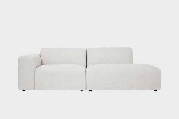 Boho-avodivaanisohva valkoisella kankaalla verhoiltuna, käsinoja vasemmalla ja divaaniosuus oikealla vaaleaa taustaa vasten.