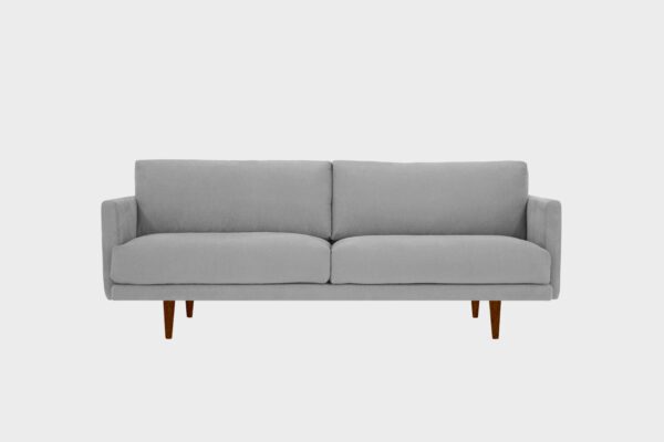 Havu 3-istuttava sohva harmaalla kankaalla verhoiltuna ja jalkoina pähkinän sävyiset puujalat, tuotekuva edestäpäin kuvattuna.