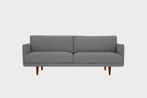 Havu 3-istuttava sohva tummanharmaalla kankaalla verhoiltuna ja jalkoina pähkinän sävyiset puujalat, tuotekuva edestäpäin kuvattuna.