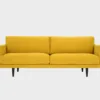 Havu 3-istuttava sohva keltaisella kankaalla verhoiltuna ja jalkoina wengen sävyiset puujalat, tuotekuva edestäpäin kuvattuna.