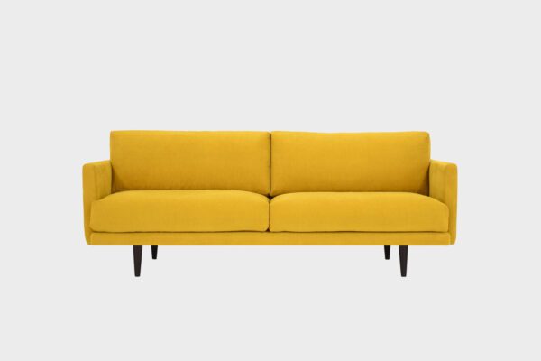 Havu 3-istuttava sohva keltaisella kankaalla verhoiltuna ja jalkoina wengen sävyiset puujalat, tuotekuva edestäpäin kuvattuna.