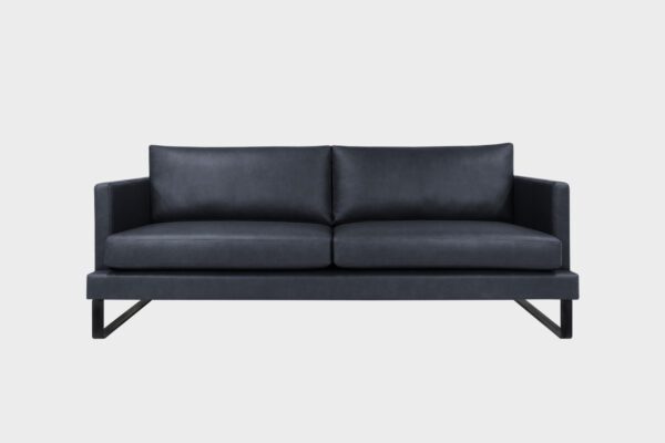 Helsinki-Kolmen istuttava sohva verhoiltuna mustalla Madras nahkalla ja jalkana metallinen kelkkajalka, tuotekuva edestäpäin kuvattuna.