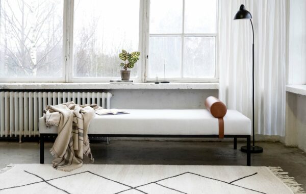 Siesta-daybed nahkatyynyllä, vaalealla kankaalla verhoiltuna, sisustuskuva.