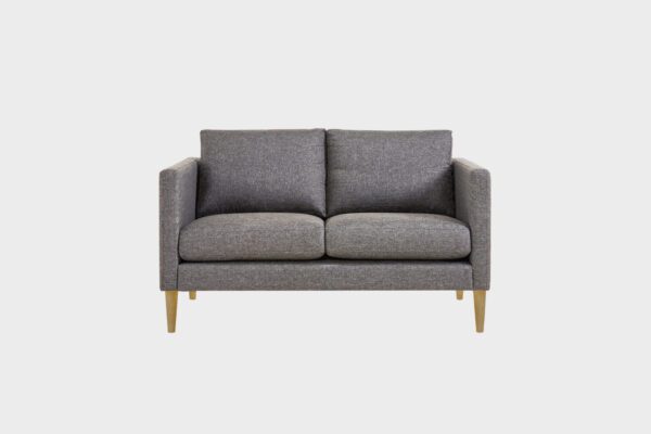 Tuohi-kahden istuttava sohva verhoiltuna harmaalla kankaalla ja jalkoina tammi puujalat, tuotekuva edestäpäin kuvattuna.