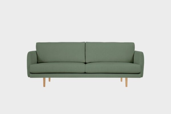 Kataja 3 istuttava sohva vihreällä villabukleekankaalla verhoiltuna ja tammen sävyisillä puujaloilla, tuotekuva.