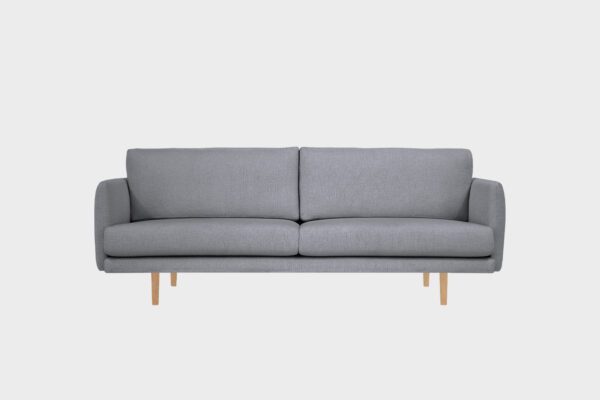 Kataja-kolmen istuttava sohva harmaalla villabukleekankaalla verhoiltuna ja tammen sävyisillä puujaloilla, tuotekuva.