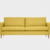 Kuura-3 istuttava sohva keltaisella kankaalla verhoiltuna ja jalkana tammen sävyiset puujalat, tuotekuva.