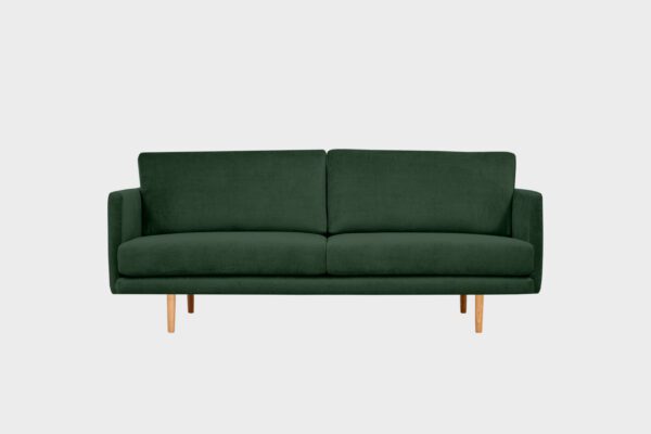 Kanerva-3 istuttava sohva vihreällä kankaalla verhoiltuna ja jalkana tammi puujalka, tuotekuva edestäpäin kuvattuna.