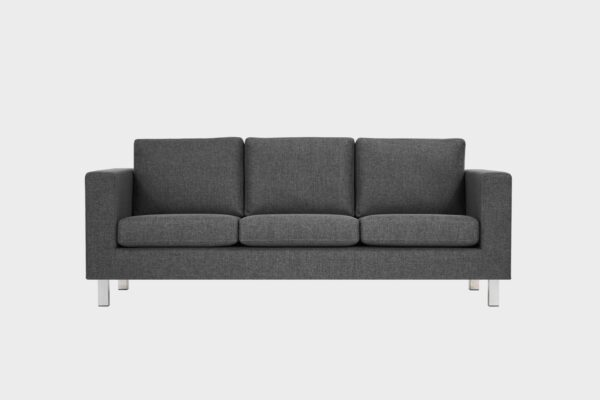 Tumman harmaa kolmen istuttava sohva kromin värisellä metallijalalla.