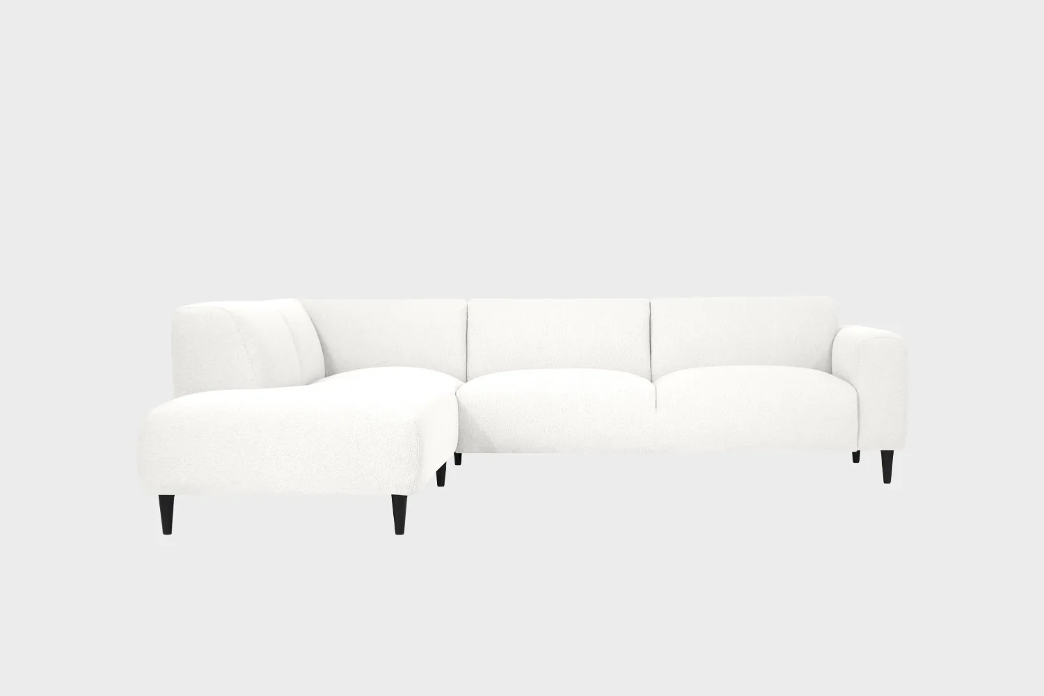 Valkoinen avokulmasohva mustilla puujaloilla ja divaanin puoli sohvan vasemmalla puolella edestä päin katsottuna.