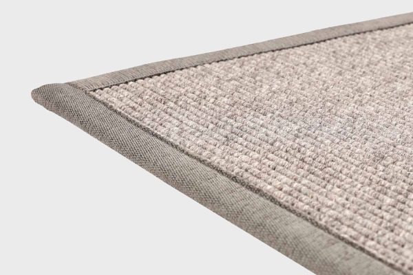 Harmaa VM Carpet Esmeralda matto. Lähikuva maton kulmasta, josta näkyy kanttaus ja maton materiaali.