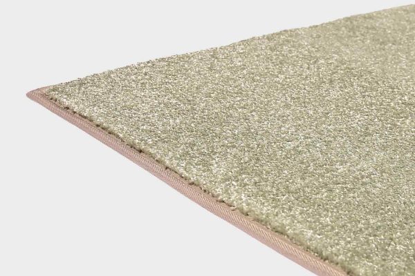 Vihreä VM Carpet Hattara matto. Lähikuva maton kulmasta, josta näkyy kanttaus ja maton materiaali.