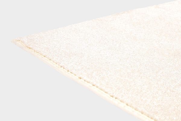 Valkoinen VM Carpet Hattara matto. Lähikuva maton kulmasta, josta näkyy kanttaus ja maton materiaali.