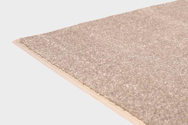 Beige VM Carpet Hattara matto. Lähikuva maton kulmasta, josta näkyy kanttaus ja maton materiaali.