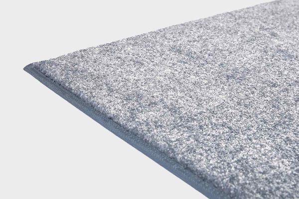 Sininen VM Carpet Hattara matto. Lähikuva maton kulmasta, josta näkyy kanttaus ja maton materiaali.