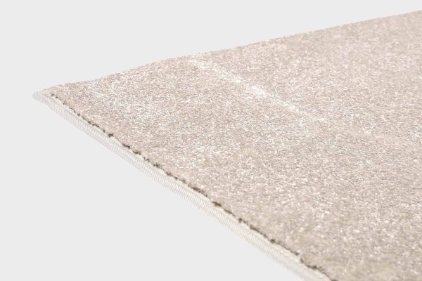 Harmaa VM Carpet Hattara matto. Lähikuva maton kulmasta, josta näkyy kanttaus ja maton materiaali.