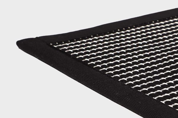 Musta VM Carpet Lyyra 2 matto. Lähikuva maton kulmasta, josta näkyy kanttaus ja maton materiaali.