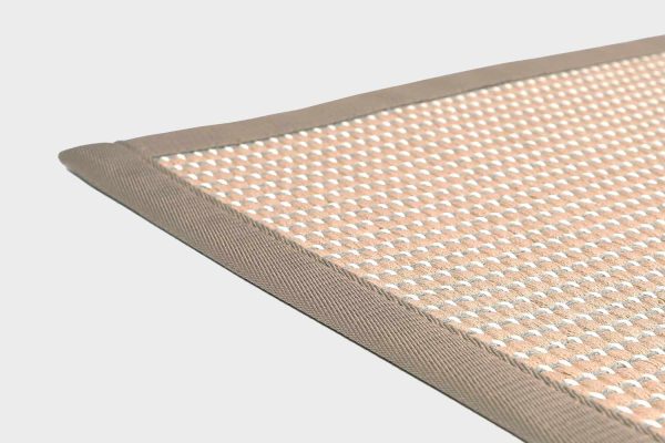 Beige VM Carpet Lyyra 2 matto. Lähikuva maton kulmasta, josta näkyy kanttaus ja maton materiaali.