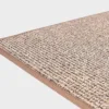 Vaalean beige VM Carpet Tweed matto. Lähikuva maton kulmasta, josta näkyy kanttaus ja maton materiaali.