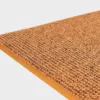 Keltainen VM Carpet Tweed matto. Lähikuva maton kulmasta, josta näkyy kanttaus ja maton materiaali.