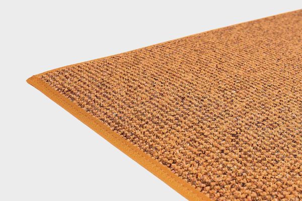 Keltainen VM Carpet Tweed matto. Lähikuva maton kulmasta, josta näkyy kanttaus ja maton materiaali.