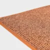 Terran värinen VM Carpet Tweed matto. Lähikuva maton kulmasta, josta näkyy kanttaus ja maton materiaali.