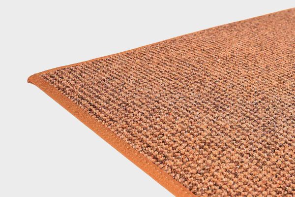 Terran värinen VM Carpet Tweed matto. Lähikuva maton kulmasta, josta näkyy kanttaus ja maton materiaali.