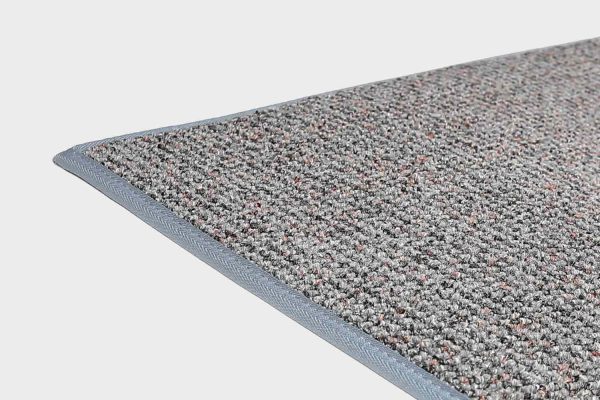 Aqua VM Carpet Tweed matto. Lähikuva maton kulmasta, josta näkyy kanttaus ja maton materiaali.