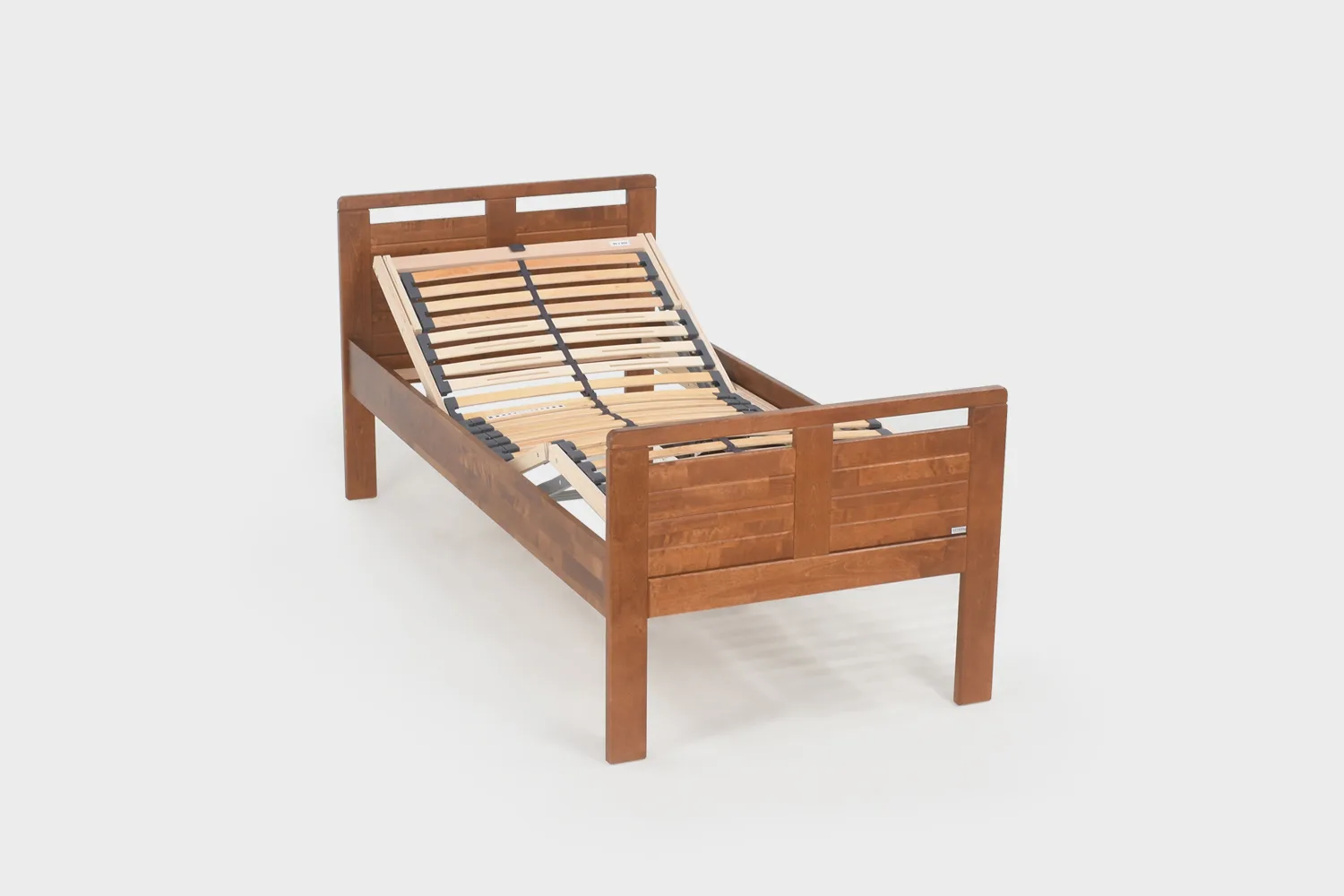 Korkea moottoroitu seniorisänky 80x200 cm pähkinänvärisenä kuvattuna viistosti edestäpäin pääty hieman kohotettuna ilman patjoja.