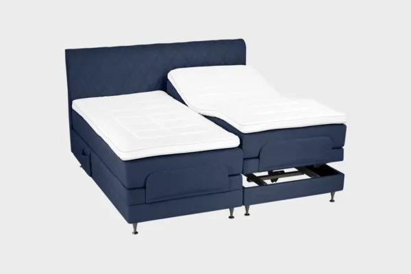 Tummansininen moottorisänky 200x200 cm mustilla jaloilla sekä samanvärisellä sängynpäädyllä. Parisänky on kuvattuna viistosti toisen sänkypuoliskon päädyt aavistuksen koholla vaaleaa taustaa vasten.